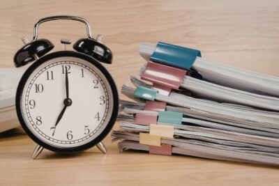 Unpaid overtime hours represented by an alarm clock next to stacked work documents