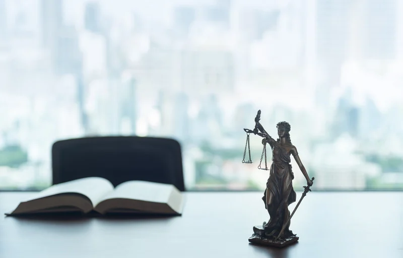 Lady Justice on desk with book, federal employment lawyers